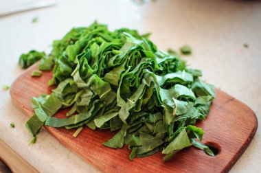 Borç ve salata için dilimlenmiş genç yeşil kuş kesme tahtasının üzerinde yatıyor, kırsal tarzda.