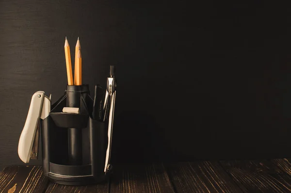 Back to school, the concept of parenting. An assortment of consumables, stands for pens and pencils, an eraser, stationery knives, compasses.Education concept.Copy space. Rustic and vintage toning.