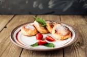 Картина, постер, плакат, фотообои "gourmet breakfast - cottage cheese pancakes, cheesecakes, cottage cheese pancakes with strawberries, mint and powdered sugar in a white plate. useful dessert on a wooden table in rustic style. selective focus.", артикул 278668264