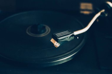 Şehir ışıkları üzerinde bir günbatımı arka plan üzerinde Vinil kayıt çalar. Dj'lerin müzik karıştırması ve çalması için ses teknolojisi. Siyah vinil kaydı. 1980 vintage vinil ahşap plak çalar. Vinil kayıt iğnesi