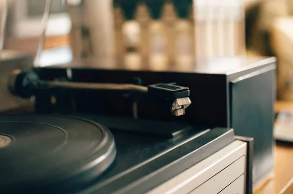 Şehir ışıkları üzerinde bir günbatımı arka plan üzerinde Vinil kayıt çalar. Dj'lerin müzik karıştırması ve çalması için ses teknolojisi. Siyah vinil kaydı. 1980 vintage vinil ahşap plak çalar. Vinil kayıt iğnesi — Stok fotoğraf