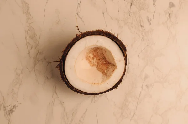 Laid organique cassé noix de coco pourrie sur un fond de marbre. une noix cassée dans une coquille l'intérieur blanc d'une noix de coco, qui a commencé à se décomposer et recouvert de champignons et de moisissures . — Photo