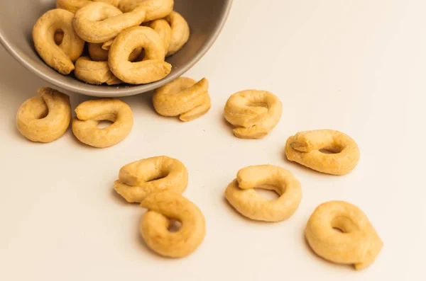 Taralli es un aperitivo italiano tradicional, similar al secado o bagels, típico de la cocina de Sicilia y Calabria. Bagel sobre un fondo blanco en un tazón . — Foto de Stock