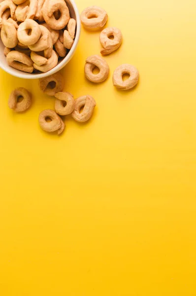 Taralli - Sicilya ve Calabria mutfağında tipik olarak kurutma veya simit benzeri geleneksel bir İtalyan aperatifi. Sarı arka planda simit. Boşluğu kopyala.