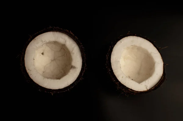 Laid noix de coco biologique sur fond noir, isoler. une noix cassée dans une coquille l'intérieur blanc d'une noix de coco, qui a commencé à se décomposer et recouvert de champignons et de moisissures. Produits gâtés . — Photo