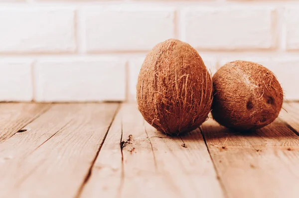 Tropische kokosvruchten op een houten achtergrond in rustieke stijl. Model voor ontwerp. Kopieerruimte. — Stockfoto