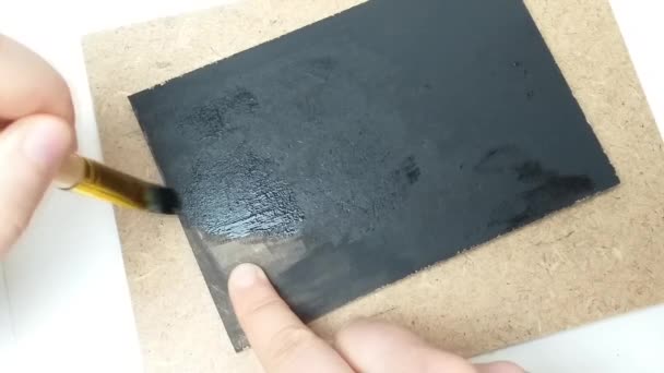 Un pincel en pintura negra gouache pinta un fondo negro en cámara lenta inversa — Vídeo de stock