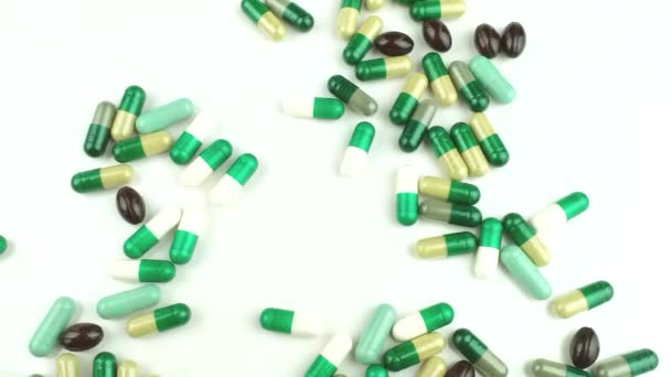 Lot of different pills lies on white background.Threw lot of pills in blister.Selective focus on pills, vitamins, medicines, medicines and dietary supplements for healthcare.Pharmaceutical industry. — стоковое видео