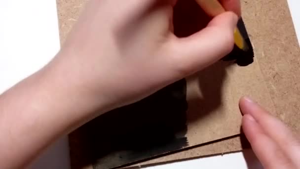 Meisje tekent met een borstel in zwart gouache verf zwart achtergrond — Stockvideo