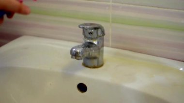 Mavi lateks eldivenli kız banyodaki lavaboya deterjan döküyor. Temizlik kavramı.