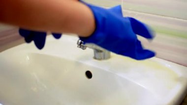 Mavi eldivenli kız lavaboyu yıkıyor, banyoyu temizliyor. Lavaboda temizlikçi olarak çalışıyorum. Temizlik ve temizlik için tuvaleti fırçala. Lavaboyu temizliyorum. Temizlik hizmeti kavramı