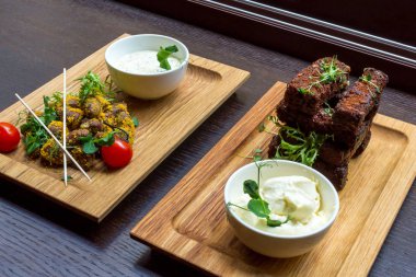 Tavuk eti aperatif ve kavrulmuş sarımsak ekmek meze beyaz soslar siyah tablo arka plan üstten görünüm üzerinde ahşap plaka üzerinde duymak