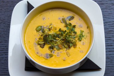 Siyah ahşap masa arka plan üstten görünüm portre üzerinde kök sebze sarı krem çorbası