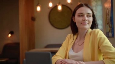 Bir kız kahve dükkanında lezzetli bir kahve içer. Garson mutlu, güzel bir kız kahvesi getiriyor. Bir kadın kafeteryada tek başına oturuyor.