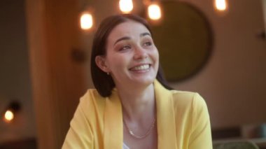 Bir kız kahve içiyor, mutlu genç bir kadın bir kafede oturuyor ve kahve içiyor. Karantinadan sonra bir kafe açmak.