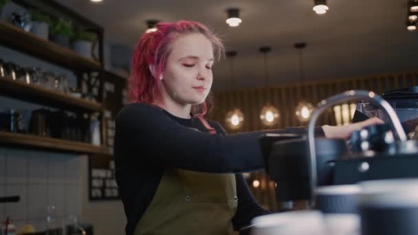 Een jonge Barista Girl maakt heerlijke koffie. Koffie winkel werknemer met een moderne kapsel, Modieuze Barista, Moderne gir — Stockvideo