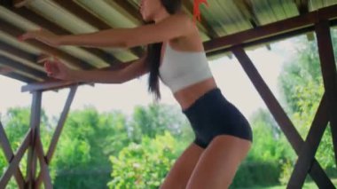 İnce bir esmer, kalçaları üzerinde egzersiz yapar. Bir kız sokakta spor yapar. Sağlıklı bir yaşam tarzı..