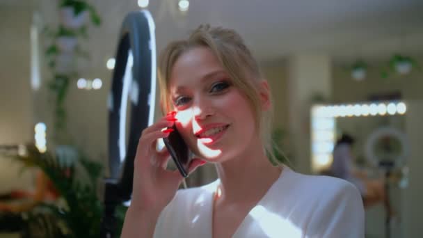 Stylowa blondynka rozmawiająca przez telefon, stylowa ładna kobieta, dziewczyna z niebieskimi oczami. Uśmiech podczas rozmowy przez komórkę — Wideo stockowe