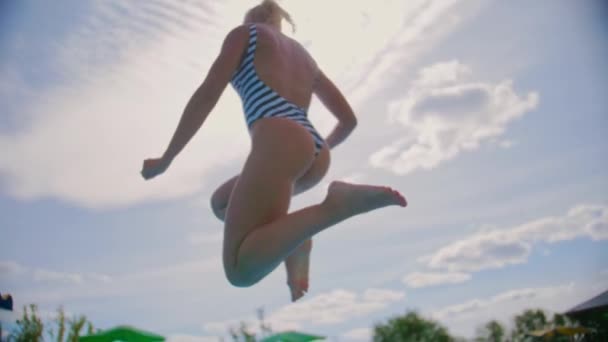 한 여자가 물 속으로 뛰어들어 카메라 속으로 물을 튀기는 모습 — 비디오