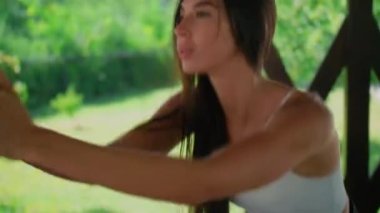 Spor yaparken bir kızın yüzüne yakın çekim, kameraya çömelmiş güzel bir esmer. Tatbikatın tanıtımı