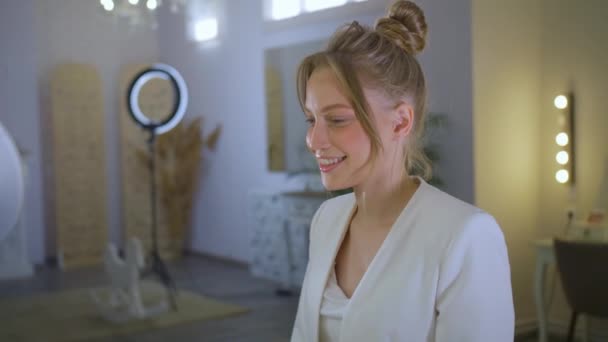 En glad ung flicka kom till en sminkspecialist, en kvinna ler, måla ögonbrynen i en skönhetsstudio — Stockvideo