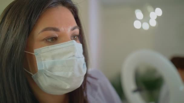 Maquillaje profesional artista hace maquillaje en una máscara, trabajo seguro de las personas en el tiempo de la pandemia covid 19 — Vídeo de stock