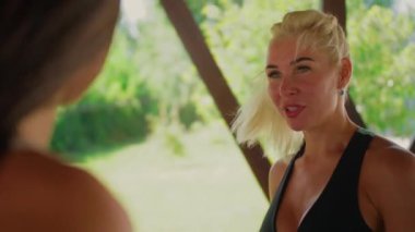 Müşterileri ve arkadaşlarıyla iletişim kuran bir bayan koçun yüzü. Bir fitness dersinden sonra kadınların konuşması