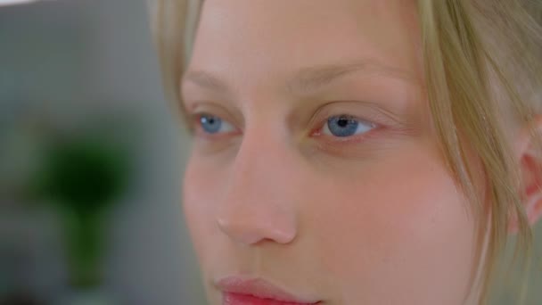 Delikatna blondynka patrzy w obiektyw, naturalne niebieskie oczy młodej kobiety, niewinne spojrzenie białej kobiety — Wideo stockowe