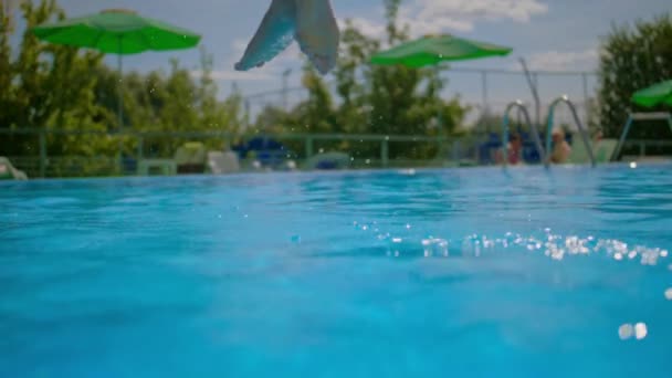 Девушка в купальнике прыгает в воду, молодая женщина ныряет в бассейн на улице, замедленная — стоковое видео