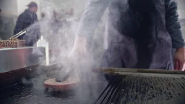 Fırında hamburger için leziz bir et pirzolası pişirmek ızgarada et pişirmek, aşçı hamburgeri kızartmak.