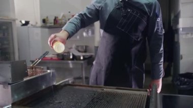 Burger et pirzolası sıcak tavada kızartılıyor. Geleneksel Amerikan hamburgerinin ızgara ayağı. Akşam yemeği için mutfakta fast food pişirme videosu.