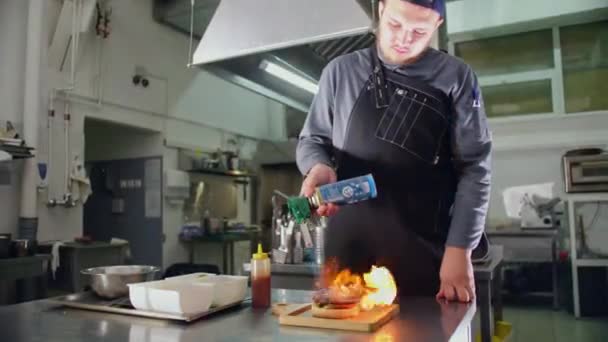 Saftiger moderner Burger, der mit einem Gasbrenner geröstet wird, und ein Fleisch-Burger vom Koch — Stockvideo