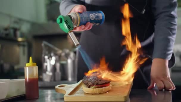 Suculento hambúrguer moderno torrado com um queimador de gás, cozinhar uma carne hambúrguer pelo chef — Vídeo de Stock