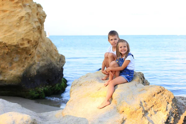 Двое детей на скалах у моря — стоковое фото