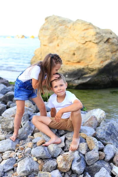 Двое детей на скалах у моря — стоковое фото