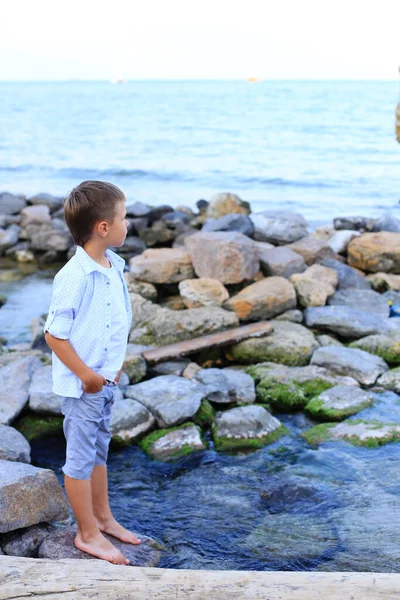 Ребенок на камнях у моря летом . — стоковое фото