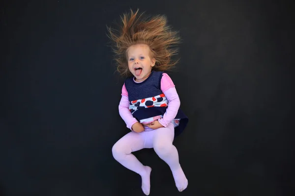 Portrait of a girl with electrified hair on a black background — Stock Photo, Image