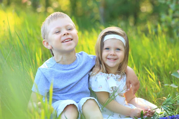 Kleiner Junge umarmt im Sommer ein Mädchen in der Natur — Stockfoto