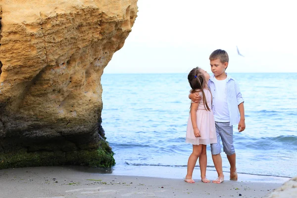 Летом на берегу моря стоят двое детей — стоковое фото