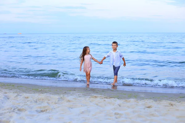 Двое детей бегут вдоль моря у берега — стоковое фото