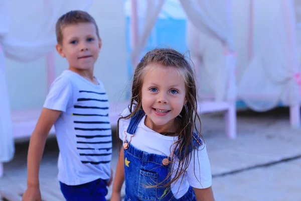 Deux enfants se tiennent au bord de la mer en été. — Photo