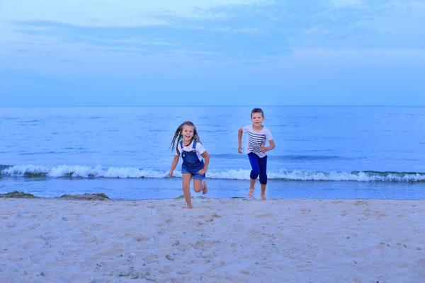 Двое детей бегут вдоль моря у берега . — стоковое фото