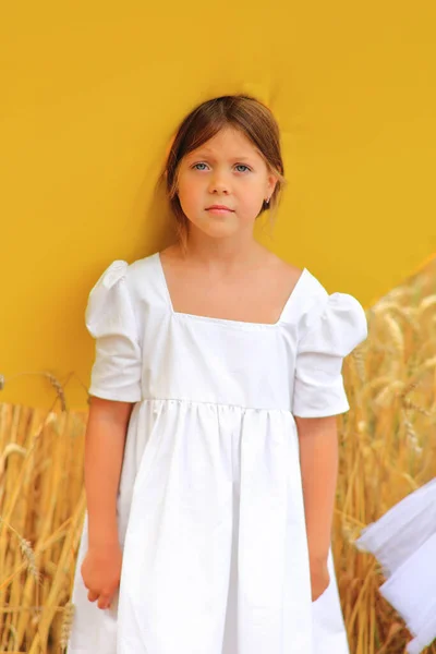 Dziecko w ogromnym żółtym kapeluszu w polu pszenicy latem — Zdjęcie stockowe