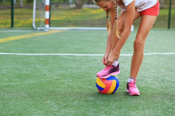 Chica con una pelota en sus manos en el patio de recreo —  Fotos de Stock