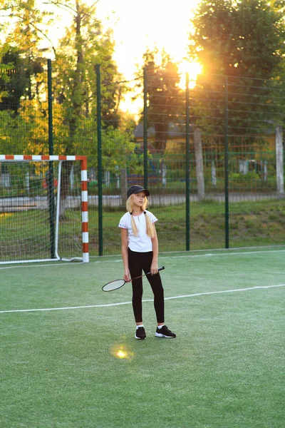 Menina com uma raquete em suas mãos no campo esportivo. — Fotografia de Stock
