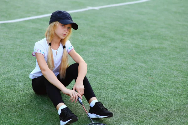 Chica con una raqueta en sus manos en el campo de deportes. —  Fotos de Stock