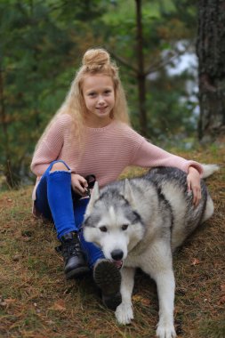 İri yapılı bir kız ormanda yürüyor..