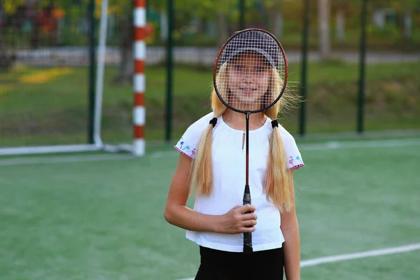 Девушка с ракеткой в руках на спортивном поле. — стоковое фото