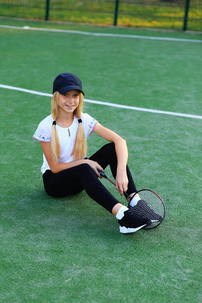 Dziewczyna z rakietą w rękach na boisku sportowym. — Zdjęcie stockowe