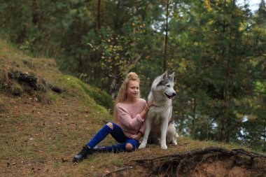 İri yapılı bir kız ormanda yürüyor..